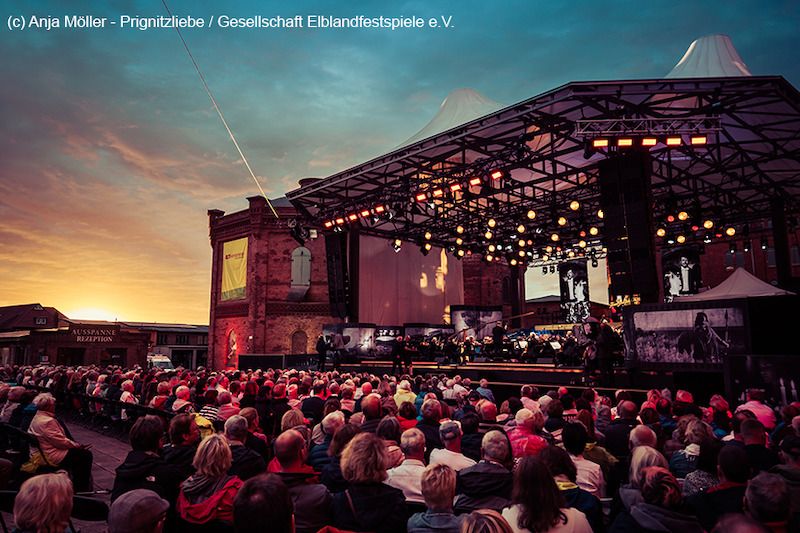 Open-Air-Bühne bei den Elblandfestspielen mit Publikum im Abendlicht.
