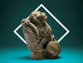 Eine Löwenstatue mit einer Schriftrolle.