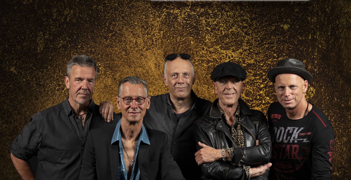 Fünf Männer posieren vor einem Hintergrund mit dem Schriftzug 'Tin Lizzy'.