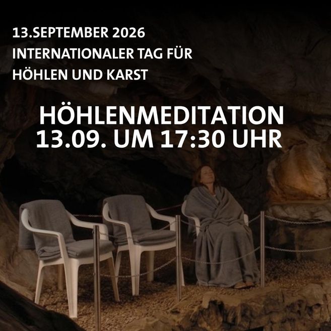A woman wrapped in a blanket sits in a chair in a cave