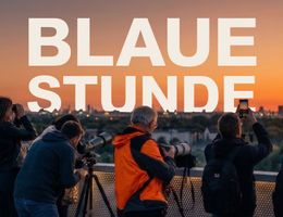 Mehrere Personen fotografieren und beobachten den Sonnenaufgang über Hamburg vom Energieberg Georgswerder aus, mit Kameras und Ferngläsern vor der Skyline im Morgenlicht.