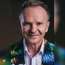 Porträt eines Mannes in einem bunten Anzug mit Comic-Motiven.