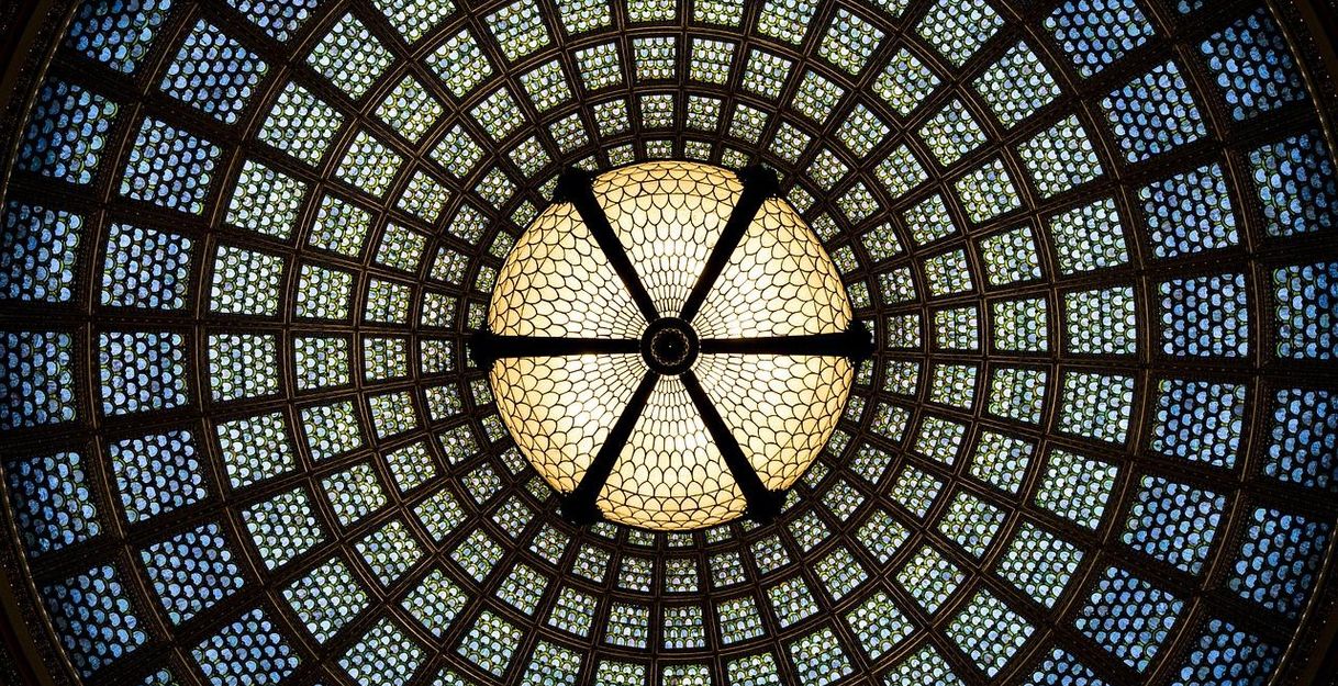 Buntes Glasdach mit kreisförmigem Muster und zentraler Kuppel.