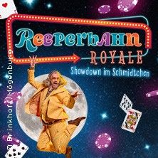 Ein Mann in einem gelben Anzug springt vor einem Mondhintergrund, umgeben von Spielkarten und Lichtern. Der Text "Reeperbahn Royale" ist prominent zu sehen.