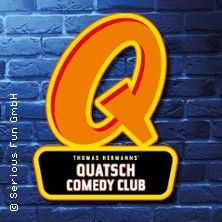 Logo des Quatsch Comedy Clubs vor einer blauen Backsteinwand.