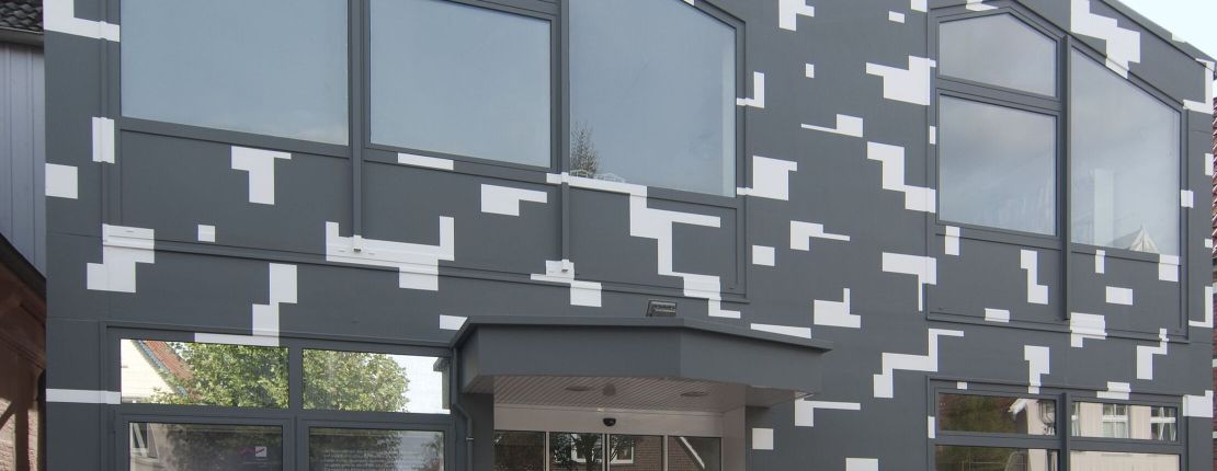 Fassade eines modernen Gebäudes mit grauen und weißen geometrischen Mustern.