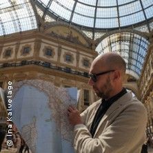 Ein Mann in einem eleganten Gebäude hält eine Landkarte in der Hand.