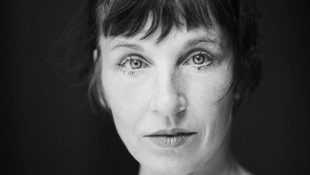 Schwarz-weiß Porträt einer Frau mit kurzem Haar und ausdrucksstarken Augen.