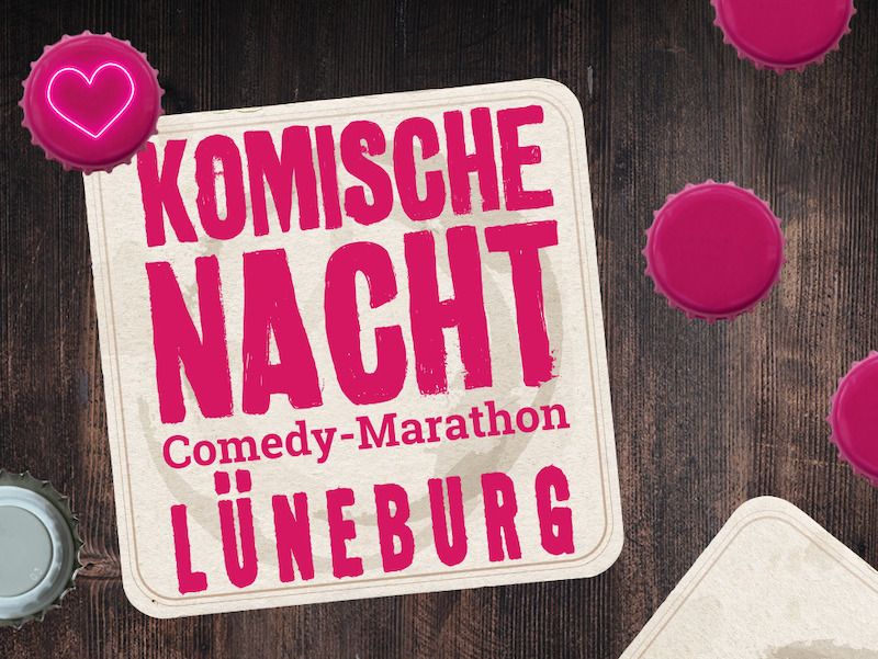Bierdeckel mit der Aufschrift 'Komische Nacht Comedy-Marathon Lüneburg' auf einem Holztisch mit Flaschendeckeln.