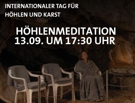 A woman wrapped in a blanket sits in a chair in a cave