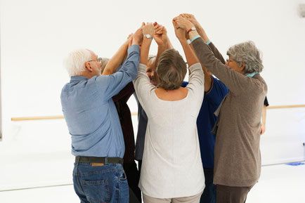 Eine Gruppe bringt die Hände in der Mitte eines Kreises zusammen