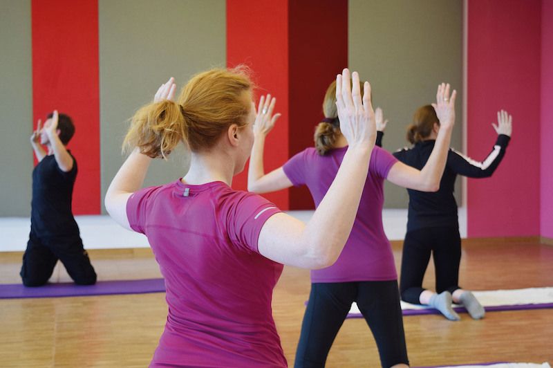 Personen machen Rückenübungen in einem Fitnessstudio.