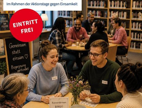 Menschen sitzen an Tischen in einer Bibliothek und unterhalten sich fröhlich.