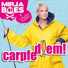 Frau in gelbem Regenmantel mit Angelrute vor blauem Hintergrund. Text: Mirja Boes - Carpfe Diem!