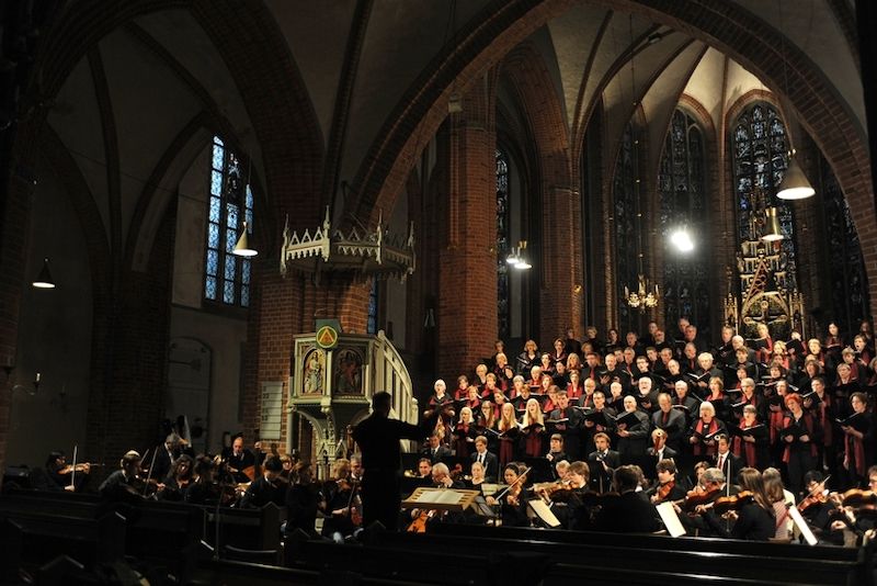 Ein Chor und Orchester führen ein Oratorium in einer Kirche auf.