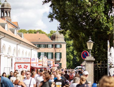 Menschenmenge auf einem Stadtfest in Eutin mit historischen Gebäuden im Hintergrund.