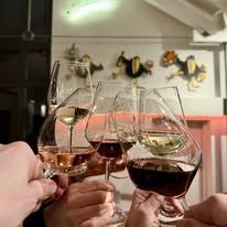 Mehrere Personen stoßen mit Weingläsern an.