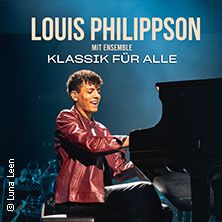 Ein Musiker spielt Klavier auf der Bühne mit einem Orchester im Hintergrund.