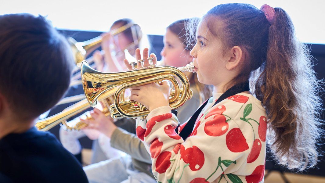 Kinder spielen Trompeten in einer Musikgruppe.