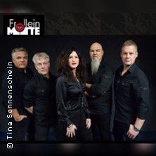 Bandfoto von Frollein Motte mit fünf Mitgliedern in schwarzer Kleidung vor dunklem Hintergrund.